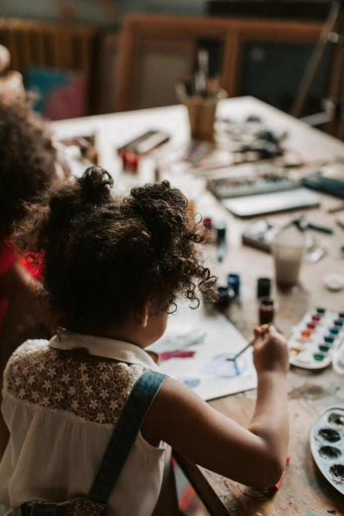 Child painting with curiosity before societal norms take over