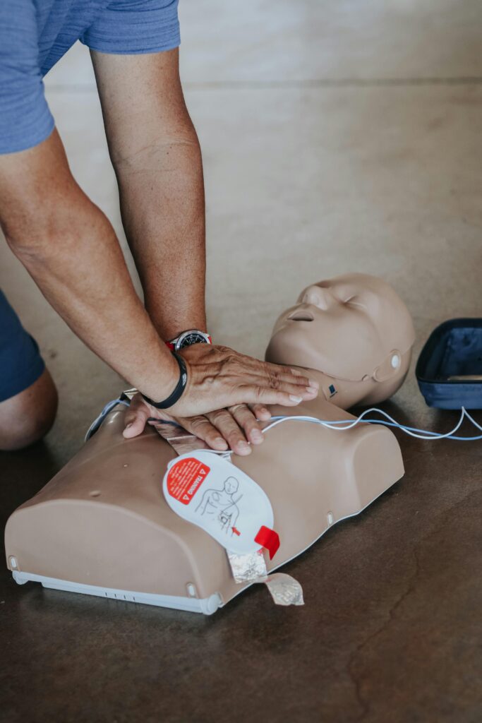 Hands performing CPR on a training dummy to demonstrate basic life-saving skills in emergency situations.