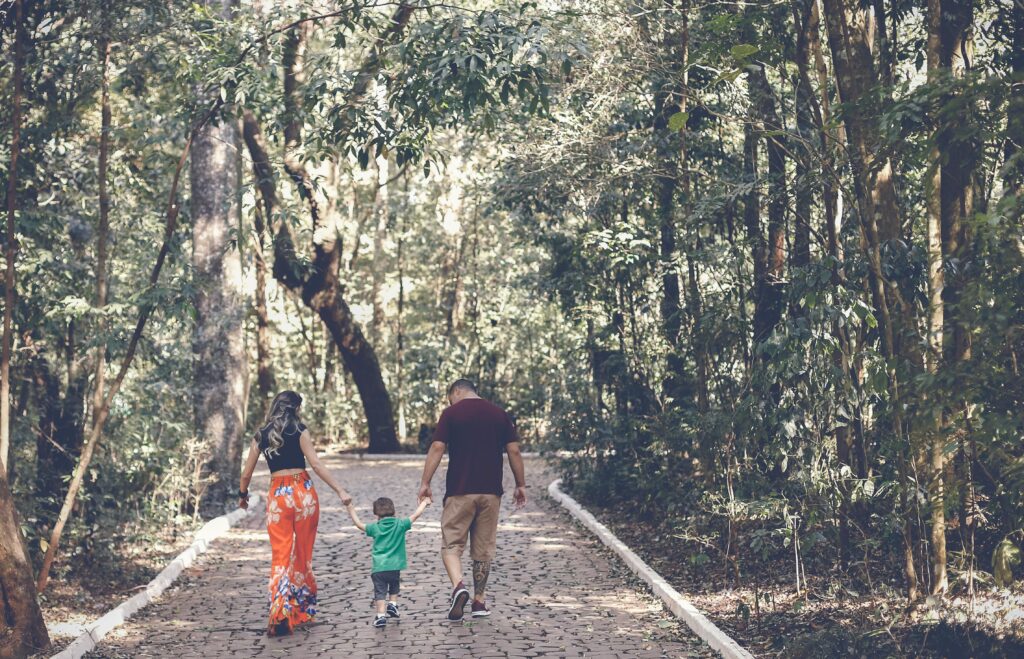 “Parents walking with child, teaching silent lessons by example”